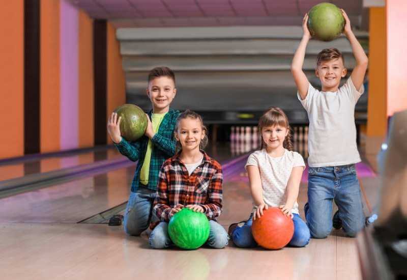 Kids are holding bowling balls